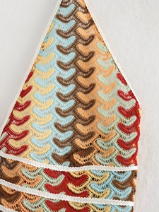 Detailed macro view of the multi-colored crochet knit pattern on a V-neck dress