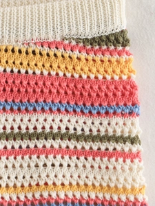 Detailed close-up of colorful striped crochet knit fabric in a bohemian style