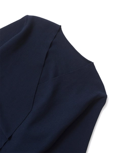 Close-up of navy blue ribbed knit fabric with deep V-neck and padded shoulder detail
