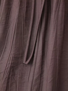 Close-up of deep purple pleated fabric texture with fine vertical crinkle details
