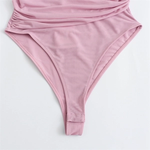 Detailed close-up of pink sleeveless bodysuit featuring side ruching and snap button closure