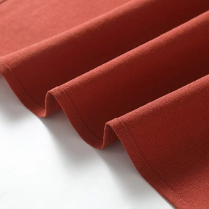 Detailed close-up of brick red knit fabric texture with professional double stitching