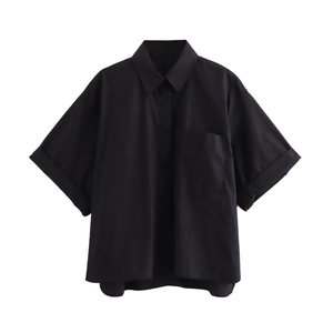 Detail of short sleeve black oversized shirt with turn-down collar and chest pocket