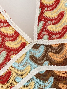 Detailed macro view of colorful crochet wavy pattern and V-neck stitching on the dress