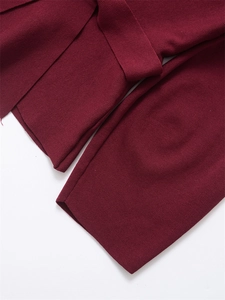 Detailed macro view of dark red ribbed knit fabric and matching waist belt texture