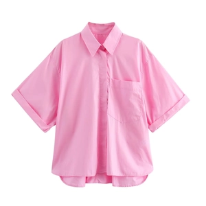 Detail of pink cotton short sleeve shirt with drop shoulder and rolled cuffs in macro view