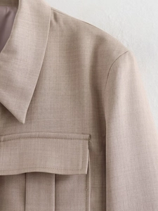 Dettaglio macro della trama in twill e della tasca con patta su una giacca corta kaki