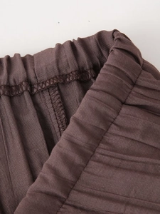 Detailed macro view of the elastic waistband on pleated brown high waist skirt
