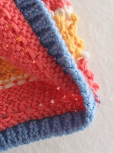 Close-up of colorful striped crochet knit fabric showing texture and soft fiber details