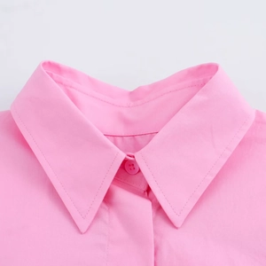 Close-up detail of the pink short sleeve shirt collar with a matching button and neat stitching