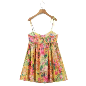 Detail of floral spaghetti strap dress showing yellow fabric and ruffle neckline