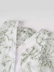 Robe longue en dentelle blanche avec broderie florale verte et dos nu à lacets