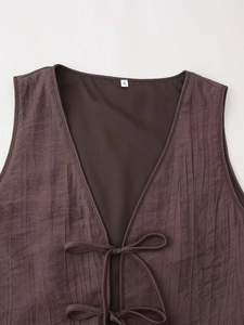 Detail of dark brown ribbed vest with tie-up V-neck and size S woven label