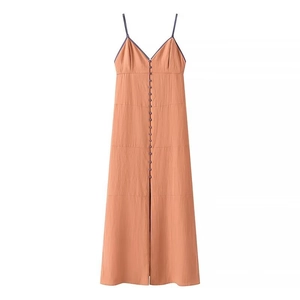 Detail view of the v-neckline and button decorations on the burnt orange maxi dress