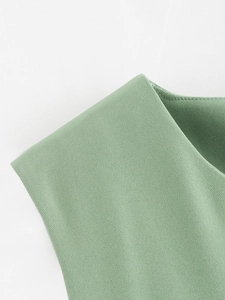 Détail d'un gilet en sergé vert clair avec coutures nettes et épaules structurées chic