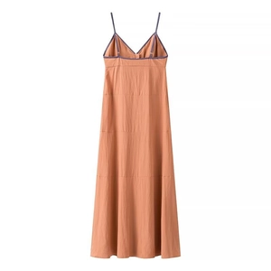 Detail of V-neck summer maxi dress with thin blue straps and layered peach fabric design