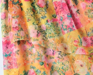 Close-up of lightweight chiffon fabric featuring vintage floral rose prints in bright colors