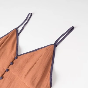 Detail of V-neck rust orange dress with purple trim and adjustable thin straps