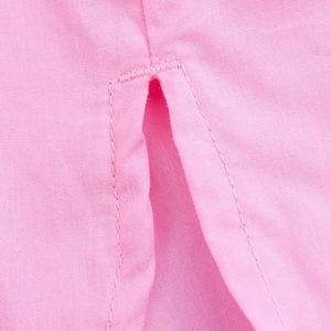 Detailed close-up of the high-quality stitching and split hem on the pink cotton shirt