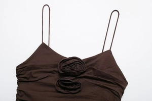 Detail of dark brown camisole showing 3D rose floral accents and crinkled texture
