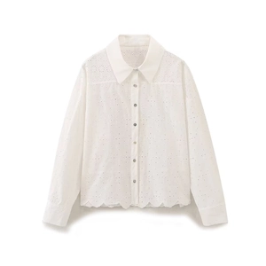 Close-up of white long-sleeved shirt with intricate eyelet embroidery and scalloped hem
