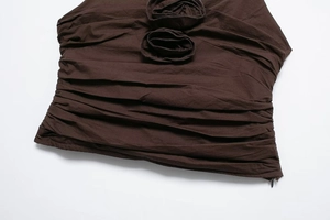 Detail of dark chocolate summer top with ruched texture and 3D fabric flower accents
