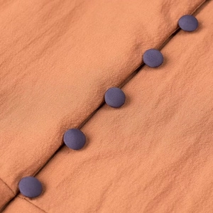 Detail shot of vintage fabric texture and decorative buttons on summer V-neck dress