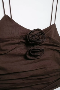 Macro detail of brown pleated camisole featuring 3D fabric rose floral accents