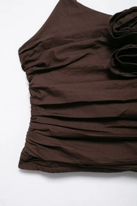 Detail of dark brown camisole showing intricate ruching and 3D fabric flower appliqué