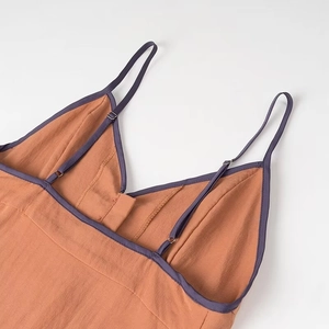 Detail of V-neck strap with adjustable silver buckle and purple contrast piping