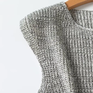 Detail shot of grey knitted sleeveless top showcasing thick fabric texture on wooden hanger