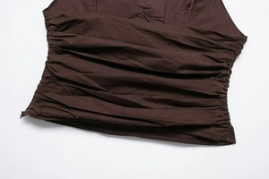 Detail view of brown ruched fabric with side invisible zipper and pearl puller charm
