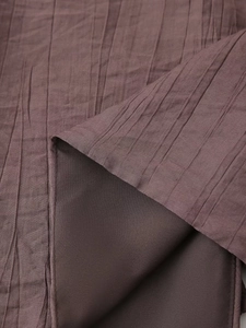 Detailed macro view of dark brown pleated fabric texture with smooth inner lining