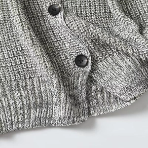 Detailed macro view of black buttons and heather grey ribbed knit texture on the cardigan