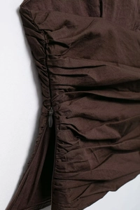 Detail of side invisible zipper and ruched texture on dark brown summer top