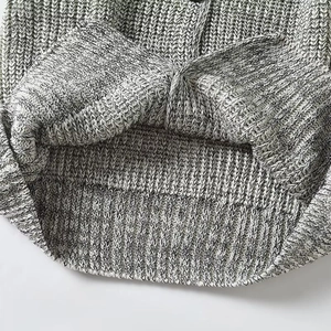 Detailed close-up of ribbed hem on black and white marl knit vest for women