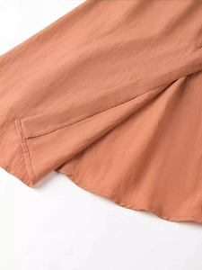 Coral V-neck backless dress with fine texture and button detail for summer vacations