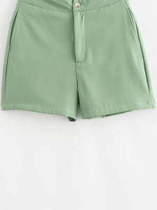 Détail d'un short décontracté vert clair avec fermeture à bouton et poches latérales