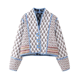 Detail of V-neck quilted jacket featuring small floral prints and blue piping trim