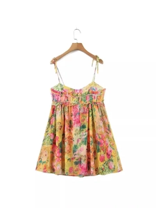 Sleeveless yellow floral summer dress with tie straps and ruffle hem on a white background