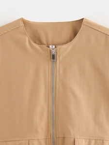 Detailansicht des silbernen Metallreißverschlusses und Größenetiketts auf der Jacke