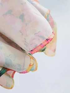 Close-up of floral summer dress hem with delicate pink piping and soft lightweight fabric