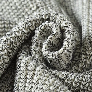 Close-up of premium salt and pepper knit fabric texture on a chunky sleeveless vest