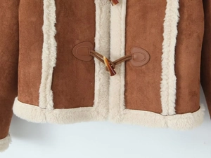 Detail der karamellfarbenen Wildlederjacke mit Lammfellbesatz und braunem Knebelverschluss