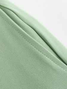 Gros plan détaillé d'un tissu sergé vert clair montrant une couture à aiguille unique