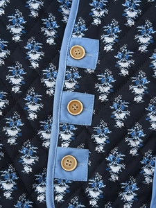 Detailed macro view of diamond quilted fabric with retro floral prints and button closures