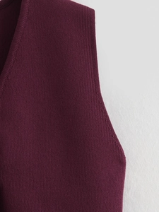 Gros plan sur le gilet en tricot bordeaux avec col en V et bords-côtes détaillés