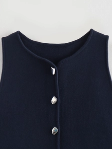 Close-up of knit vest featuring unique silver buttons and refined ribbed texture