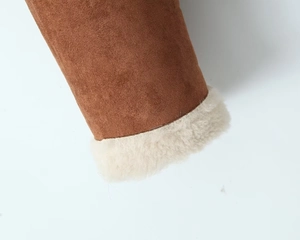 Detailaufnahme der braunen Velourslederjacke mit weichem weißem Lammfell-Innenfutter