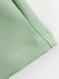 Gros plan détaillé sur tissu sergé vert sauge avec coutures plates de haute qualité